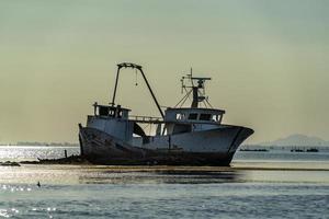 barco de pesca naufragio en las rocas foto