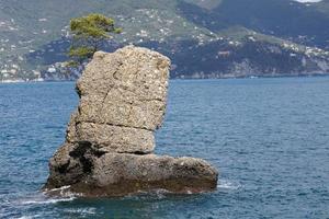 boot shape rock in the sea photo