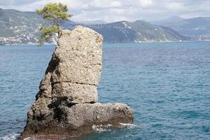 roca con forma de bota en el mar foto