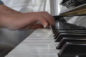 Hands playing piano while moving photo