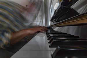 Hands playing piano while moving photo