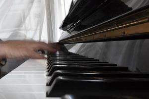 Hands playing piano while moving photo