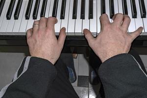 Hands playing piano while moving photo