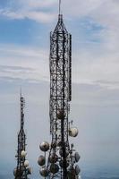 torre de antena de comunicación celular de telecomunicaciones sobre fondo azul foto