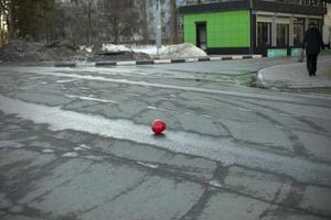 bola roja en la ciudad. pelota en la carretera. foto