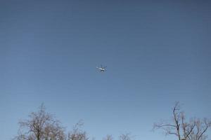 Small helicopter in blue sky. Aircraft. photo