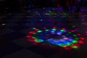 Disco on dance floor. Flower spots on floor. Color music indoors. photo