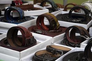 Muchos cinturones de cuero en el mercado italiano a la venta foto