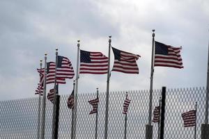 Waving usa flags behind fence grid photo