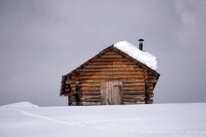 cabaña de madera en el fondo de la nieve del invierno foto