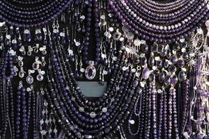 collar de amatista aretes de joyería en un puesto de exhibición en un mercado de tiendas foto