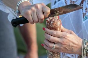 mujer manos cortando salami