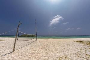 red de voleibol en playa tropical foto