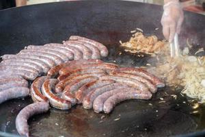 sausage while cooking on barbecue photo