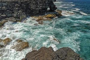 pico island waves on lava cliffs photo