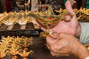 hands rubbing on alladin lamp photo