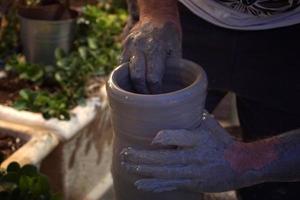 Hands working on pottery closup detail photo