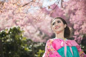 Hanbok, the traditional Korean dress and beautiful Asian girl with sakura photo