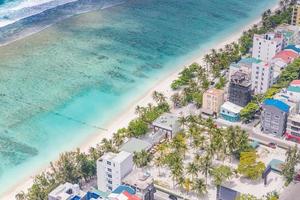 ciudad masculina, maldivas. capital maldiva e isla local desde arriba. isla hulhumale con casas y arrecifes de coral foto