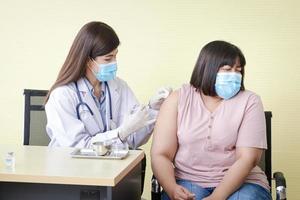 hermosos médicos asiáticos vacunaron el coronavirus en mujeres obesas. concepto de servicio médico hospitalario, vacuna antiviral foto