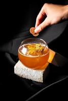 cóctel: ginebra infusionada con ciruela seca, vermut seco infusionado con ciruela, drambuie, zumo de lima, sirope foto