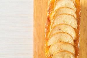 Pan de manzana desmenuzado sobre tablero de madera foto