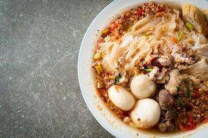 noodles with pork and meatballs in spicy soup photo