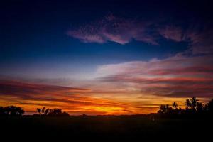 Beautiful evening sky at sundown over a village in Indonesia photo