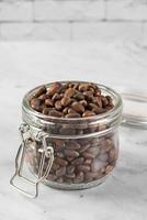 Pine nuts in a jar in the kitchen on a light background. photo