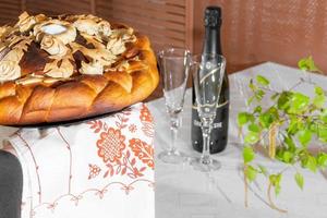 Bread served on the table with an embroidered towel. Loaf wedding cake close-up photo