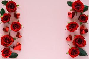 rosas rojas y hojas con pliegue de papel en forma de amor puesto en fondo rosa para el concepto de día de san valentín. foto