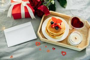 Homemade pancakes with berries, flowers and gift box. Breakfast or brunch for Valentine's Day. Mockup. Blank for greeting card for text photo