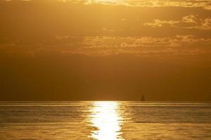 small sailboat at sunset photo