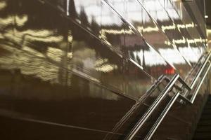 Reflection in wall of light. Handrail for climbing stairs. photo