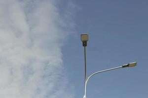 Street light during day. Pole with lamp. Urban electricity. photo