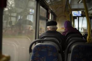 People on bus. Seating on public transport. Seats in interior of bus. Passengers in transport. photo