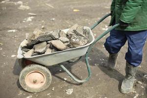 Transportation of broken stone. Worker dismantles block of stones. photo