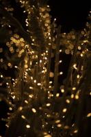 Yellow lights in dark. New Year's texture. Wood made of garlands. Lots of lights.