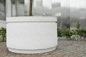 White pot for tree in park. Flower bed for plant. Park facility. photo