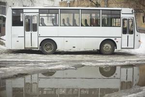 Bus and puddle. White transport.