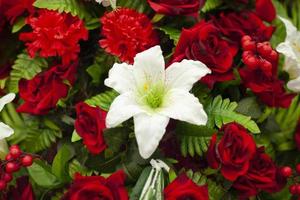 Flowers on monument. Artificial flowers on memorial. Solemn wreath on day of mourning. photo