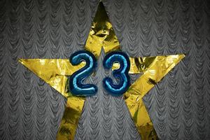 número 23 de globos. decoración con números. la estrella de oro cuelga de la tela. foto