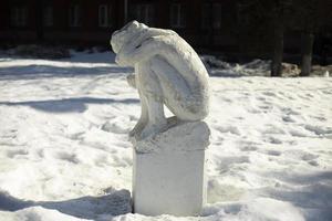 estatua en el parque en invierno. figura de yeso en la calle. chica de piedra foto