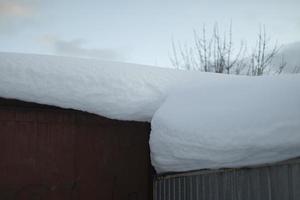 nieve en el techo. gran capa de nieve en la casa. foto