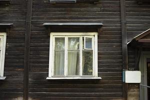 Window in old house made of boards. House of 20s. Old architecture. photo