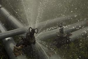 Pipeline burst. Water pours from pipes. Industrial disaster. photo