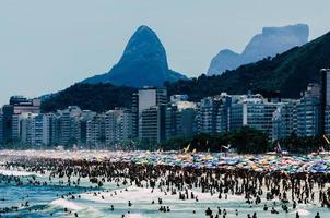 multitud de personas en la playa de leme y copacabana en un caluroso día de verano, río de janeiro, brasil foto