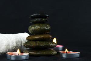 Las capas de piedras calientes se usan para masajes iluminados con velas y terapia de masajes para el diseño de paredes, patrones, carteles y pancartas. foto