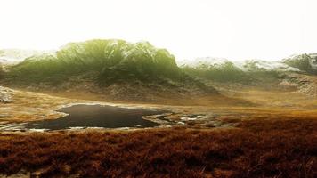 Rocky desert landscape with sparse vegetation and mountains peaks photo