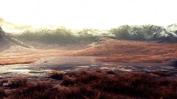 Rocky desert landscape with sparse vegetation and mountains peaks photo